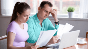 hombre y mujer mirando sus facturas para saber como reunificar deudas